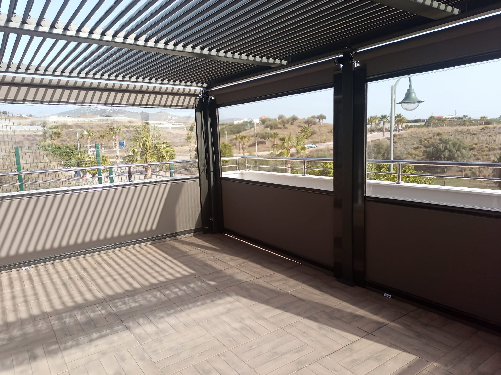 Pérgola bioclimática antracita con cerramiento lateral de cristal - Servitoldos Daniel
